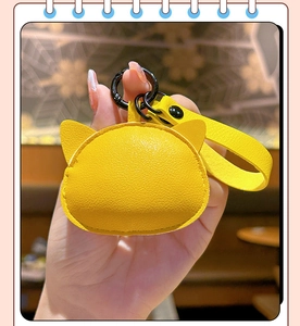 Close-up of a yellow cat-shaped leather keychain pouch with black metal ring and strap