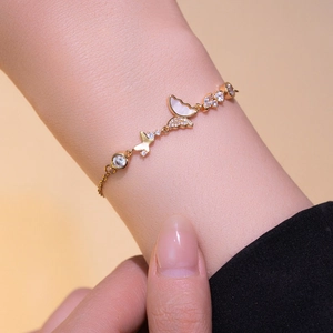 Elegant gold butterfly bracelet with white shell and zircon on female model wrist
