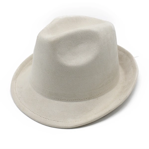 Détail d'un chapeau fedora crème avec texture en daim et coutures délicates sur le bord