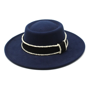 Detail of navy wool felt boater hat featuring black grosgrain ribbon and white bead trim