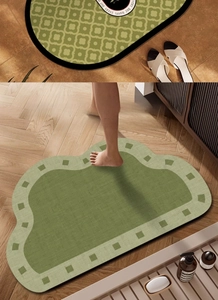 Detail of soft green cloud-shaped bath mat with absorbent diatom mud texture on wood floor