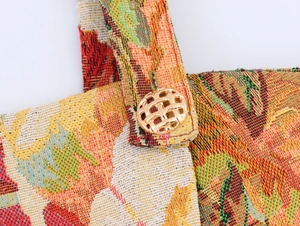 Detail of colorful jacquard fabric strap featuring an ornate gold hollow metal button