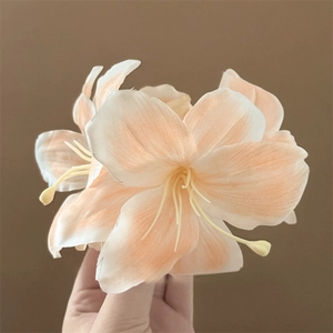 Close-up of realistic 3D lily flower hair claw clip with orange and white gradient petals