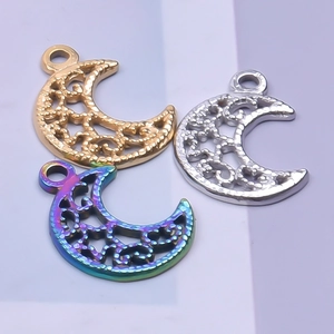 Detail of hollow moon pendants in gold, silver, and iridescent finishes with carving