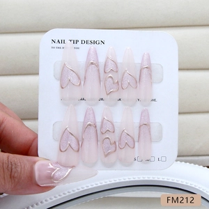 Pink pearlescent stiletto press-on nails with golden heart detailing and 3D accents
