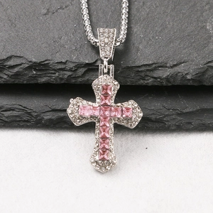 Detail of silver cross pendant with pink center stone and sparkling clear zircon gems