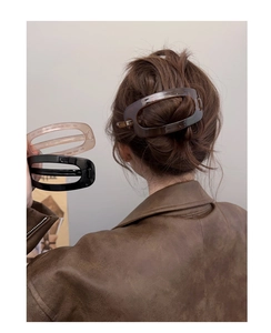 Détail de trois barrettes ovales minimalistes en noir, rose et résine écaille de tortue