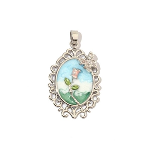 Detail of vintage silver oval pendant with pink rose enamel art and small butterfly