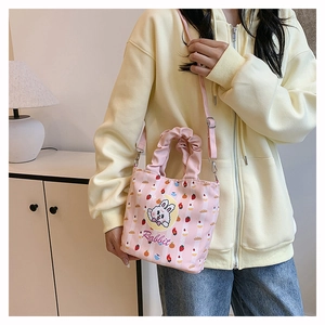 Pink striped canvas bucket bag with rabbit print and pleated handle shown on model