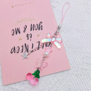 Pink bow and cherry phone charm with star pendant on elegant white lace background