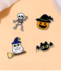 Detailed view of Halloween enamel pins featuring pumpkin, skull, and owl on a beige surface