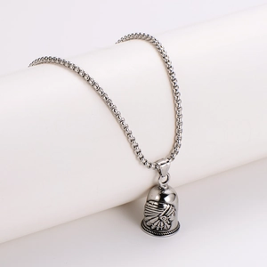Retro stainless steel Indian chief bell pendant necklace on a minimalist display