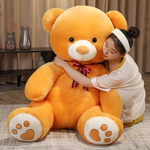 Detail of giant orange plush teddy bear with Just for you silk ribbon and heart embroidery