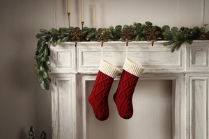 Close-up of red and white knit Christmas stockings hanging on a white festive fireplace