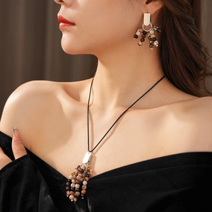 Close-up of vintage beaded necklace and earrings set worn by a model in soft lighting