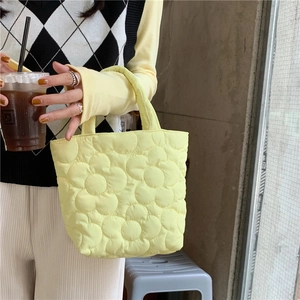 Quilted yellow puff hand bag with floral pattern for women showing casual urban style