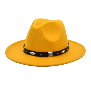 Detail of yellow wool fedora featuring a black leather band with silver metal studs