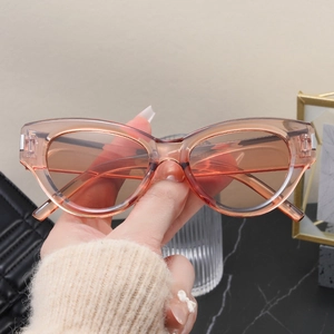 Detail of translucent amber pink cat eye sunglasses with silver metal corner accents