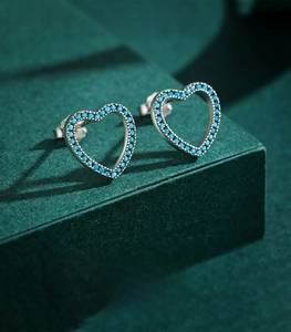 Détail de boucles d'oreilles cœur en argent 925 avec pierres turquoise bleues