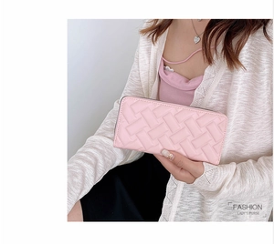 Detail of pink PU leather long purse with elegant woven texture and sturdy stitching