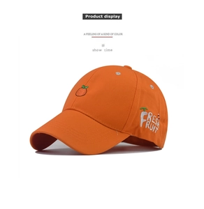 Detail view of bright orange cotton baseball cap with fresh fruit embroidery and side text