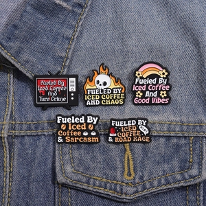 Set of 5 enamel pins on denim jacket featuring cute cartoon and coffee themed designs