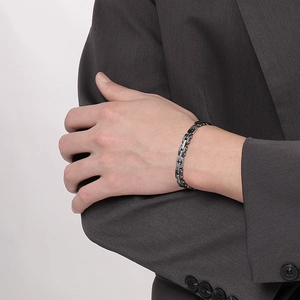 Men's stainless steel anchor bracelet with black and silver chain links worn by a model