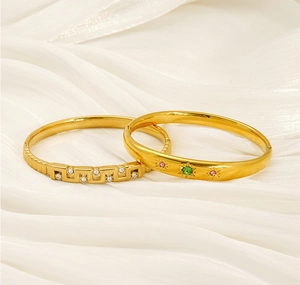 Détail de deux bracelets plaqués or avec cristaux géométriques et pierres multicolores
