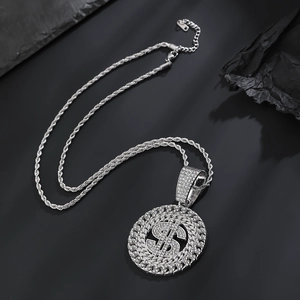 Gros plan du pendentif signe dollar en argent avec diamants et chaîne torsadée style hip hop