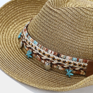 Detailed shot of bohemian straw hat with colorful band, starfish and shell ornaments