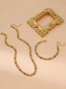 Detail of colorful enamel leaf jewelry set including gold-plated necklace and bracelet