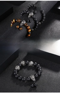 Detail of men's punk beaded bracelet featuring natural tiger eye and volcanic stone
