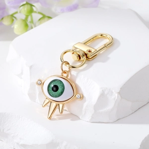 Detailed shot of golden Evil Eye keychain with green eye and sparkling crystals pendant