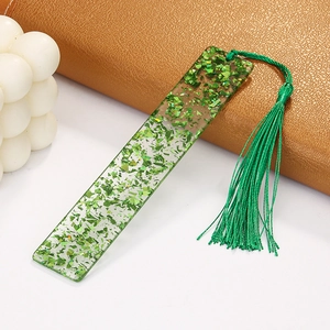 Detailed macro view of green acrylic bookmark with glitter flakes and matching tassel