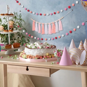 Close-up of pink and coral tassel garland with pom-pom wall hanging for party decor