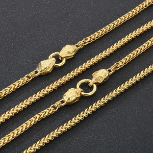 Macro detail of punk style gold steel chains with snake and skull head clasps