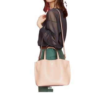 Minimalist light pink PU leather tote bag with gold stud detail and adjustable strap