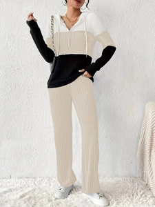 Detail of three-color patchwork hoodie and matching pants set in white, beige, and black