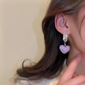 Close-up of model wearing purple zircon heart drop earrings with gold plating
