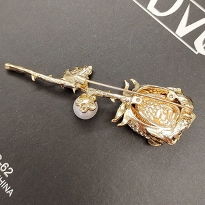 Elegant gold rose brooch with sparkling diamonds and pearl charm shown from the back view