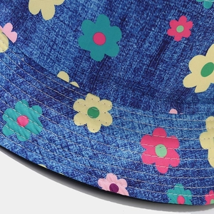 Gros plan d'imprimés marguerites colorées sur un chapeau bob en jean avec surpiqûres