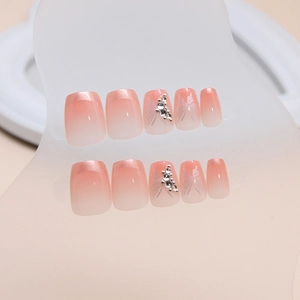 Faux ongles dégradés roses style français avec motifs papillon et strass brillants