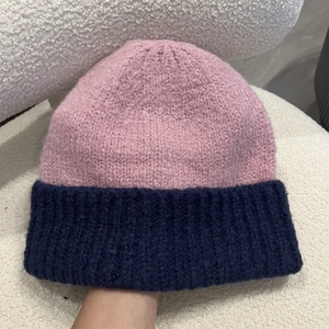 Detailed macro shot of pink and navy blue thick knit texture on a winter beanie hat