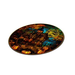 Detail of Halloween round acrylic ornament with stained glass style haunted house and pumpkins