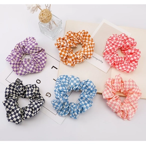 Set of six colorful checkered fabric scrunchies in purple, orange, red, and blue tones