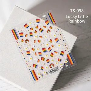 Detail of 3D embossed nail art stickers with rainbow and sun egg motifs on white stone