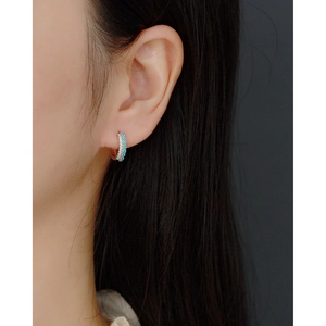 Detail view of double-row pavé hoop earrings with blue stones and white zircon