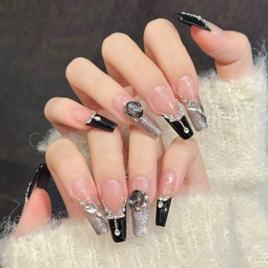 Nahaufnahme von gotischen schwarzen French-Nägeln mit Katzenaugen-Glitzer und Diamanten