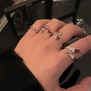 Set of four silver metal rings with red enamel in gothic Y2K style on model hand