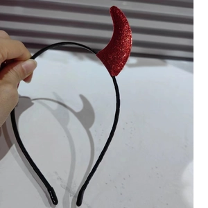 Close-up of red glitter devil horns on a black plastic headband for Halloween party
